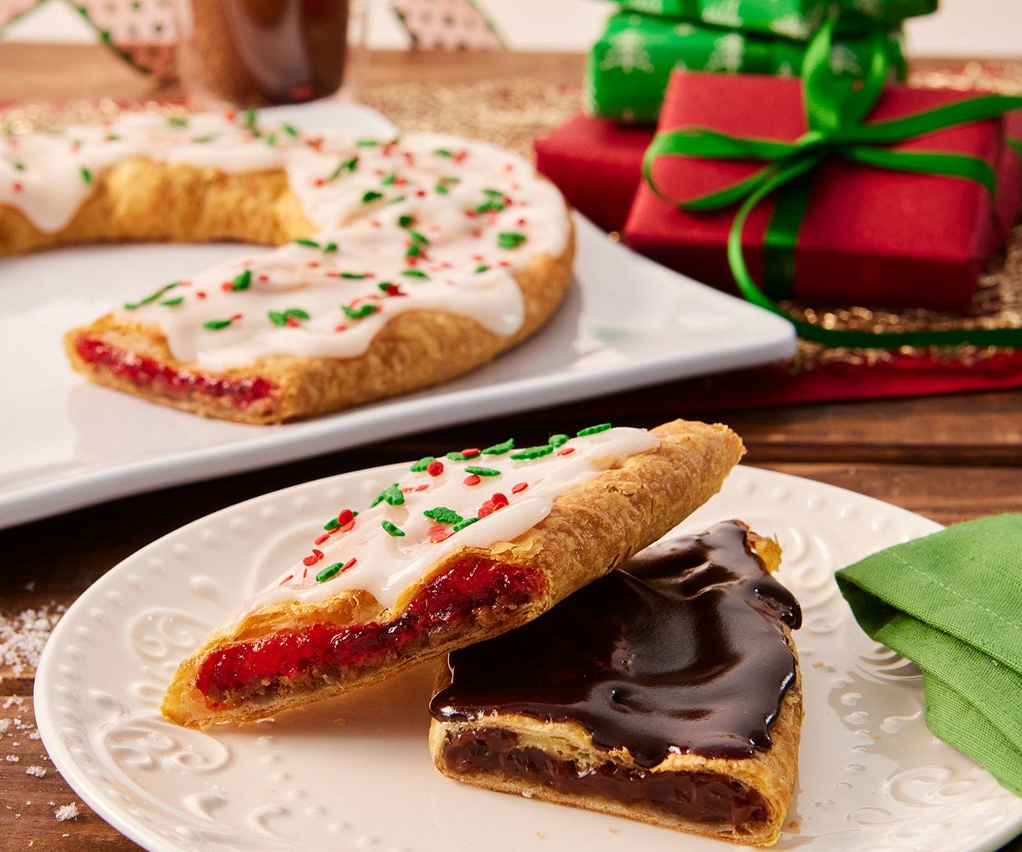 Close up of white frosted Kringle with Christmas sprinkles and chocolate frosted Kringle