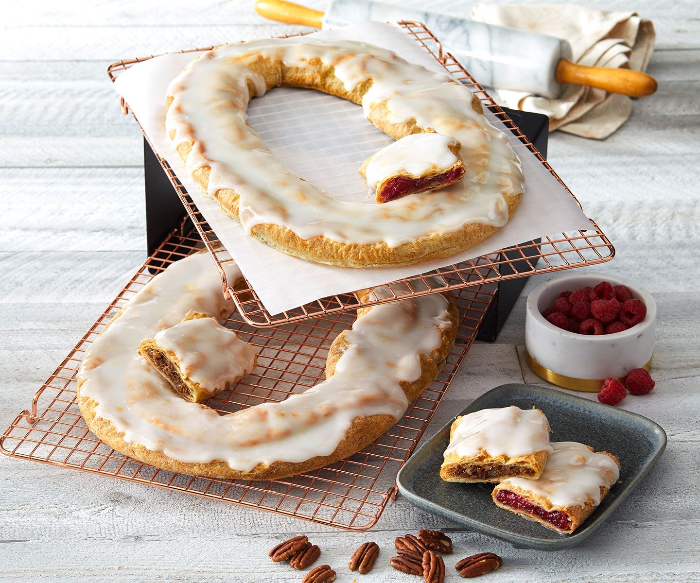 Two frosted Kringles on cooling racks