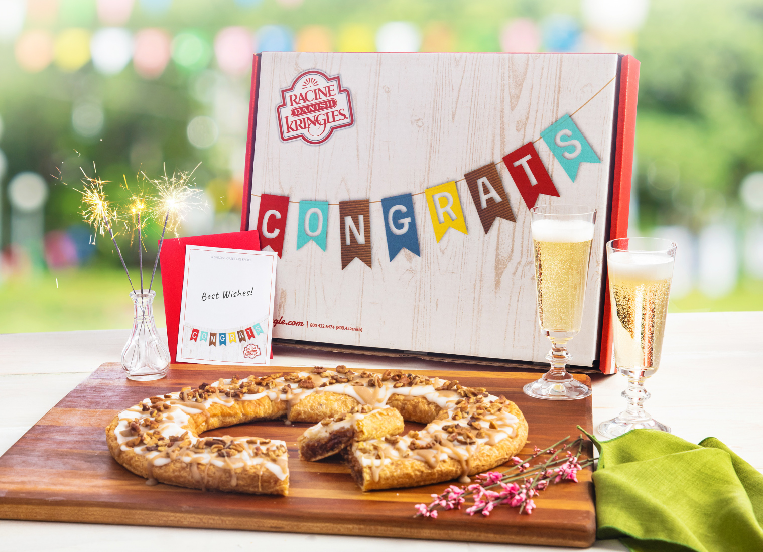 Congratulations Gift Box surrounded by champagne flutes, and Kringle
