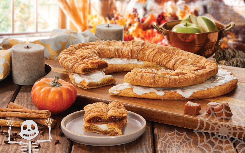 Apple-Cinnamon Kringle and Pumpkin Caramel Kringle on a plate surrounded by fall items. 