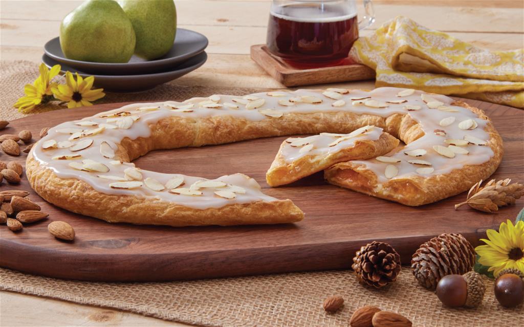 Pear Almond Kringle surrounded by pears and almonds. 