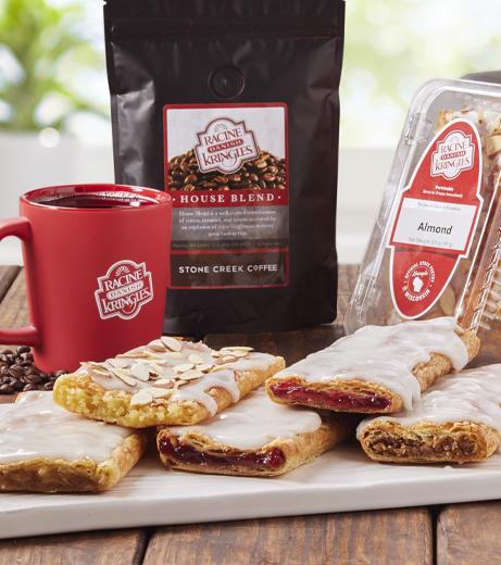 Slices of kringle on white plate with bag of coffee, single-served packaging and coffee mug.