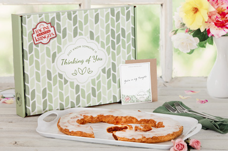 Green box with Thinking of You type with one Kringle in front flowers and cutlery