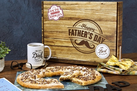 Bourbon pecan kringle in front of a wood grain patterned box and a 'Best Dad Ever' mug