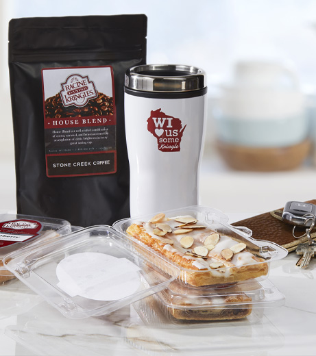 Single-served sized Kringle in packaging with coffee bag, travel mug, keys and wallet. 