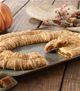 Pumpkin Caramel Kringle on a grey plate with pumpkins and cubed caramels on the side. 