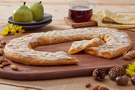 Pear Almond Kringle on a wooden cutting board with almonds.