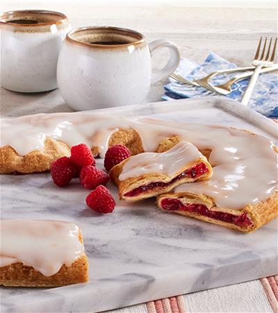 Our most popular fruit flavor! Baked in a buttery cpastry, our Raspberry Kringle has a filling of slightly tart, handpicked raspberries which perfectly complements the sweetness of our vanilla icing. A not-too-sweet, not-too-tart treat for anyone and everyone to enjoy!
