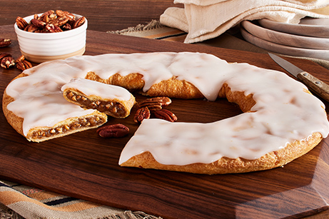 Pecan Kringle on white plate with bowls of butter, sugar and pecans.