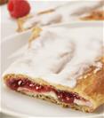 Raspberry Cheesecake Kringle on white plate, slice on smaller plate surrounded by raspberries. 