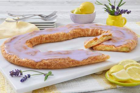 Lavender Lemon Kringle on a marble cutting board with lemons and lavender around the kringle.