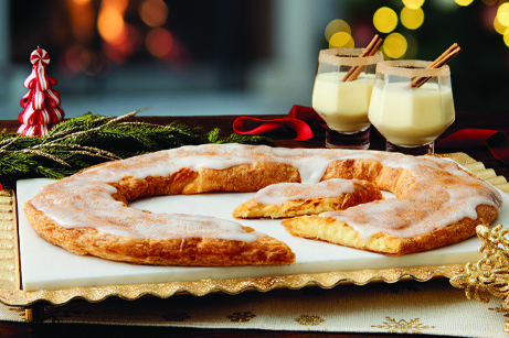 Eggnog Kringle with red ribbon and glasses of eggnog with cinnamon sticks